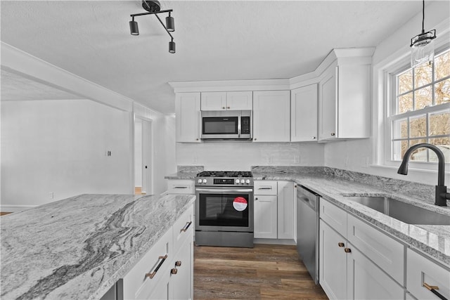 kitchen with stainless steel appliances, white cabinetry, sink, and dark hardwood / wood-style flooring