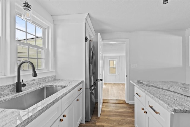 kitchen featuring white cabinetry, sink, light stone counters, and dark wood-type flooring