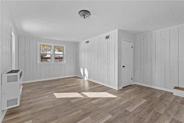 spare room featuring hardwood / wood-style flooring and radiator