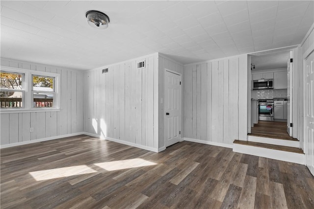 unfurnished room with dark wood-type flooring