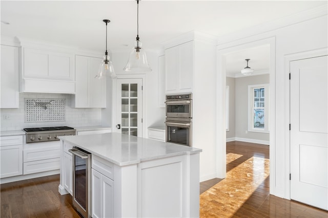 kitchen featuring wine cooler, appliances with stainless steel finishes, a kitchen island, and white cabinets