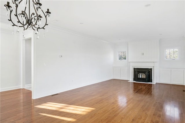 unfurnished living room with hardwood / wood-style flooring and ornamental molding