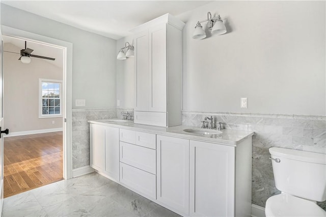 bathroom featuring vanity, ceiling fan, tile walls, and toilet