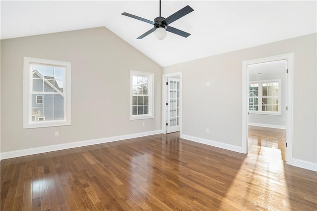 empty room with ceiling fan, dark hardwood / wood-style flooring, vaulted ceiling, and a wealth of natural light