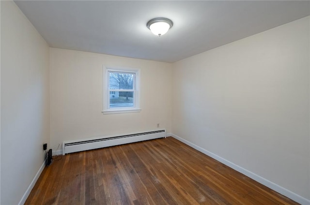 spare room featuring dark wood-type flooring and baseboard heating