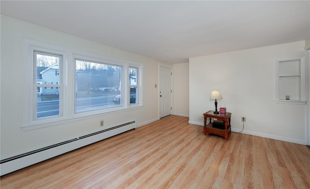 spare room with light wood-type flooring and baseboard heating