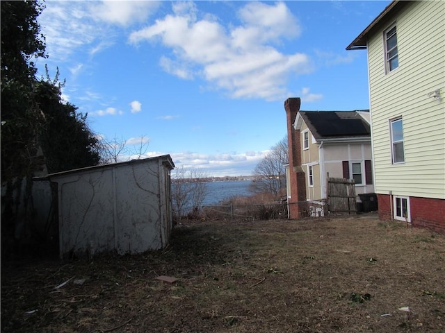 view of yard with a water view and a storage shed