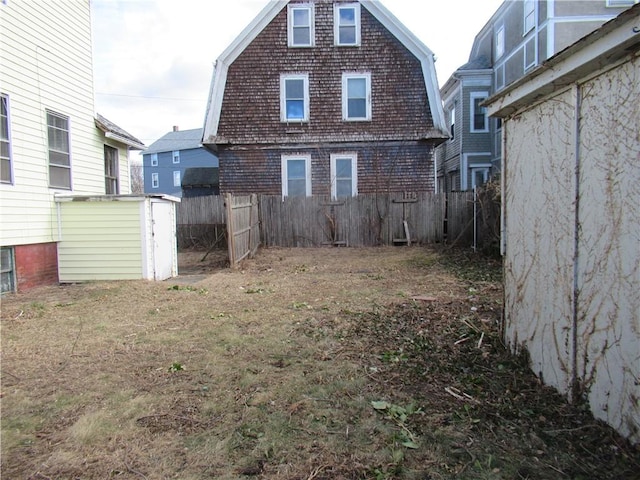 back of house featuring a storage unit