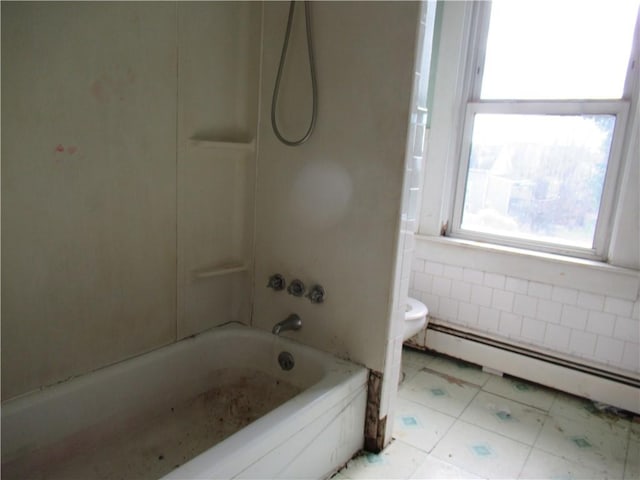 bathroom with shower / bathing tub combination, a baseboard heating unit, tile walls, and toilet