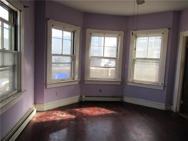 empty room with dark wood-type flooring and baseboard heating