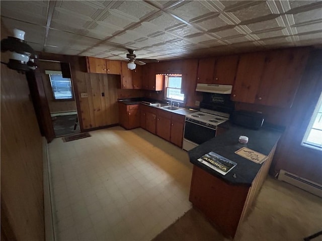 kitchen with a baseboard radiator, sink, wooden walls, and white range with electric cooktop