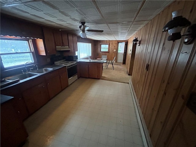 kitchen featuring sink, plenty of natural light, wooden walls, white electric stove, and kitchen peninsula