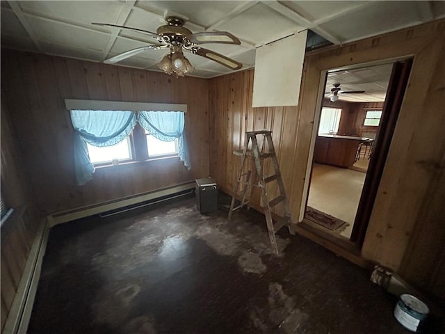 spare room featuring ceiling fan, wood walls, and a baseboard heating unit