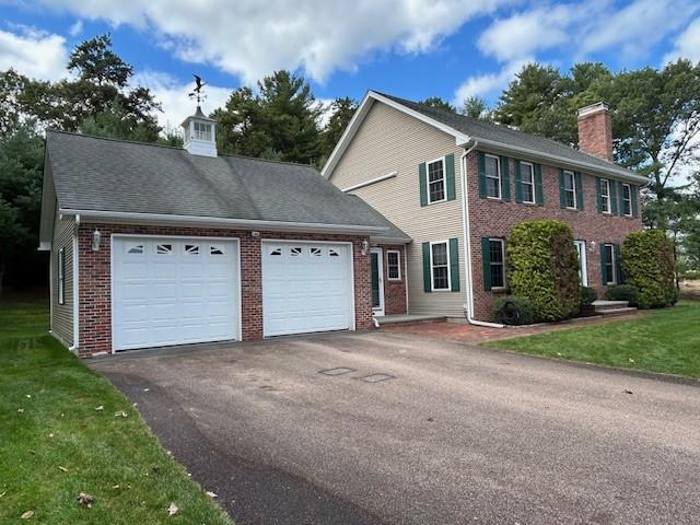 colonial inspired home with a garage and a front yard