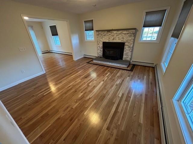 unfurnished living room featuring hardwood / wood-style flooring and a baseboard radiator