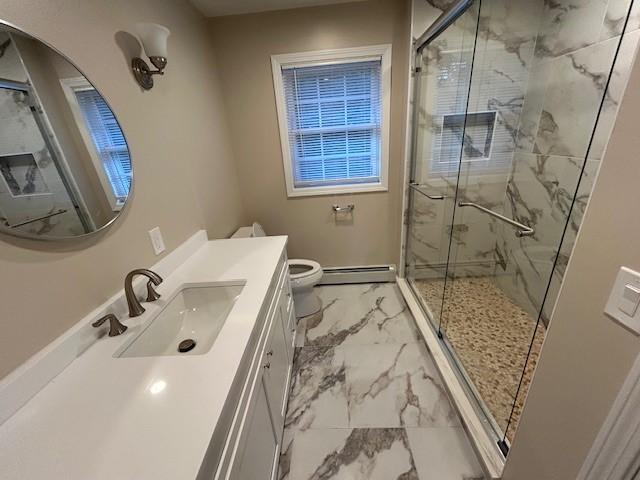 bathroom with vanity, a baseboard radiator, a shower with door, and toilet