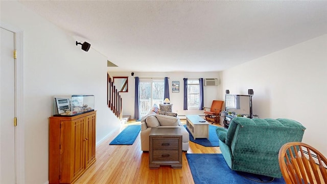 living room with light hardwood / wood-style floors and a wall mounted AC