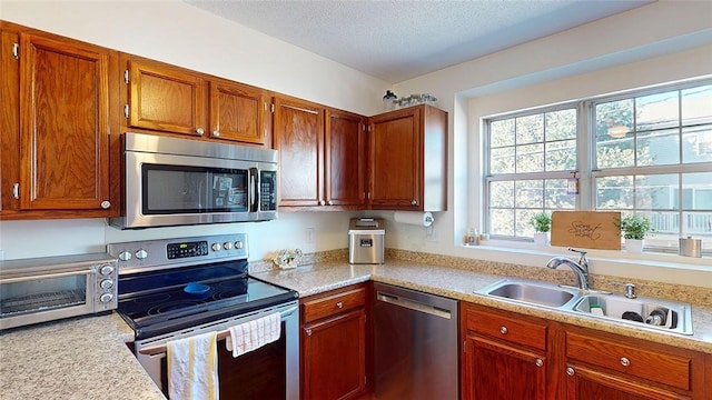 kitchen featuring stainless steel appliances, sink, and a textured ceiling