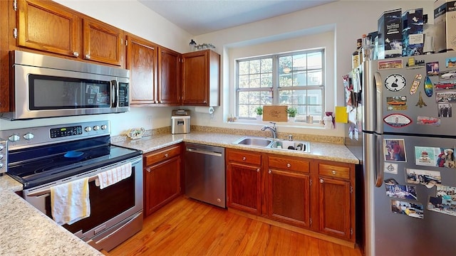 kitchen with sink, light hardwood / wood-style floors, and appliances with stainless steel finishes