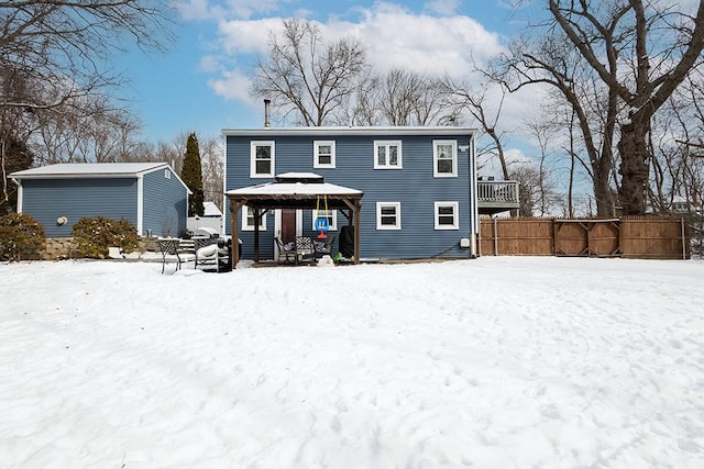 snow covered back of property with a gazebo