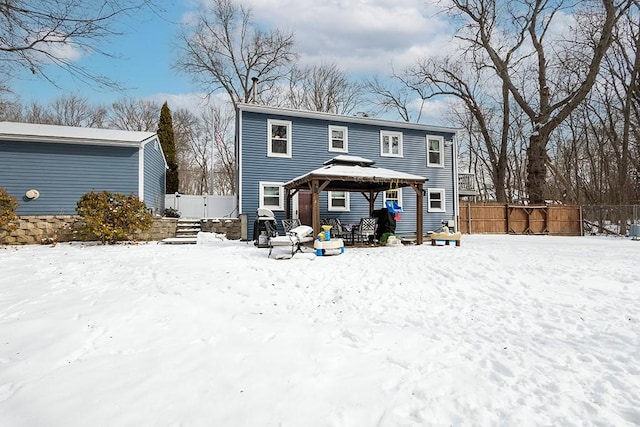 snow covered back of property featuring a gazebo