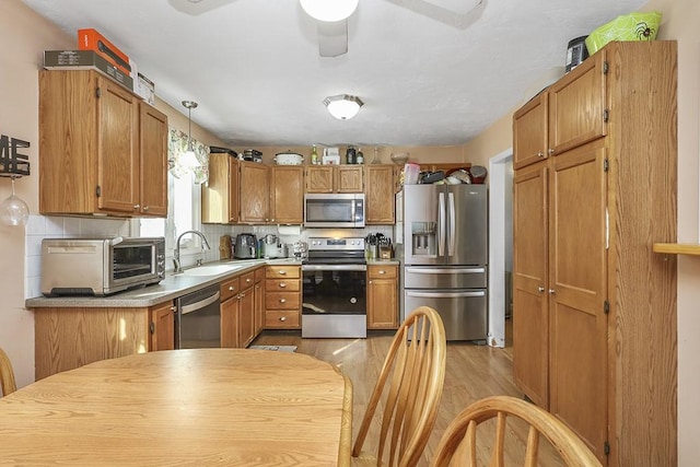 kitchen featuring tasteful backsplash, appliances with stainless steel finishes, sink, and pendant lighting