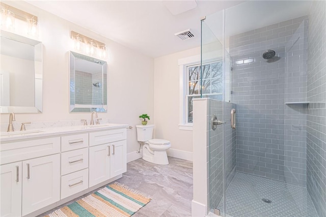 bathroom featuring vanity, a shower with shower door, and toilet