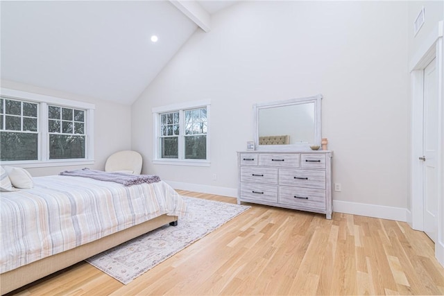 bedroom with high vaulted ceiling, light hardwood / wood-style floors, and beamed ceiling