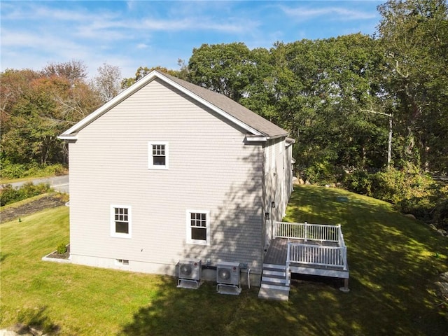 view of home's exterior featuring cooling unit, a deck, and a lawn