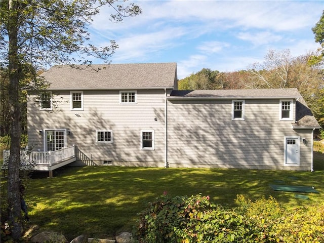 rear view of property with a lawn and a deck