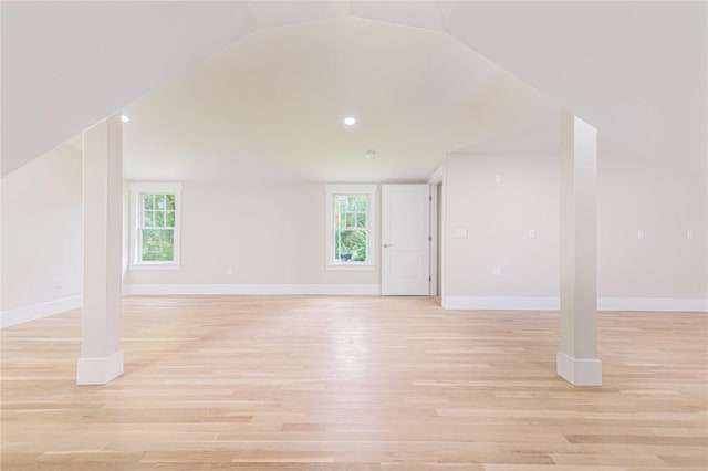 bonus room featuring vaulted ceiling, plenty of natural light, and light hardwood / wood-style floors