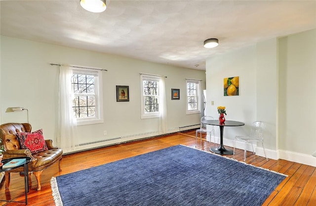 living area featuring hardwood / wood-style floors and a baseboard heating unit