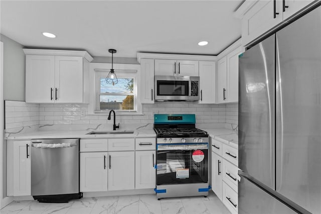 kitchen with stainless steel appliances, sink, white cabinets, and decorative light fixtures