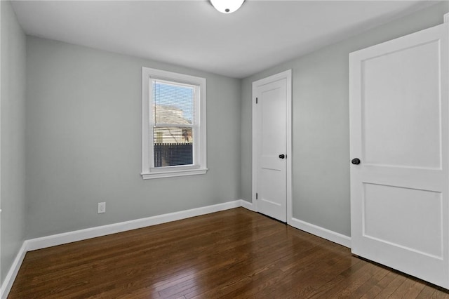 unfurnished bedroom with dark hardwood / wood-style flooring