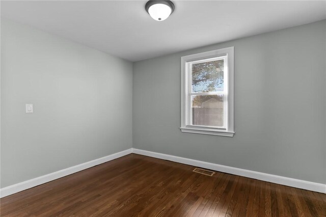 spare room with dark hardwood / wood-style floors