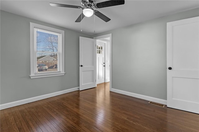 spare room with dark hardwood / wood-style flooring and ceiling fan