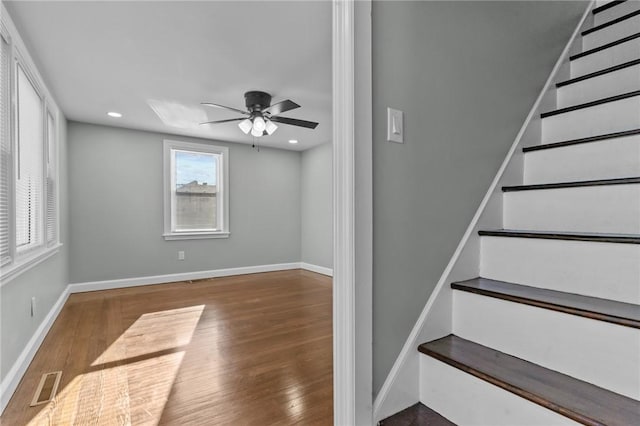 staircase featuring ceiling fan and wood-type flooring