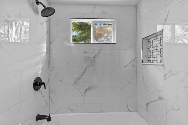 bathroom featuring tiled shower / bath