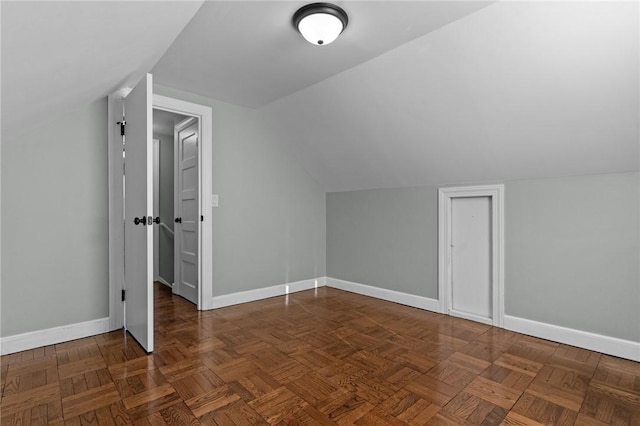 additional living space with lofted ceiling and dark parquet flooring