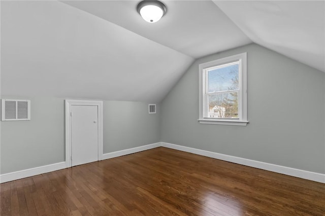 additional living space with dark wood-type flooring and vaulted ceiling