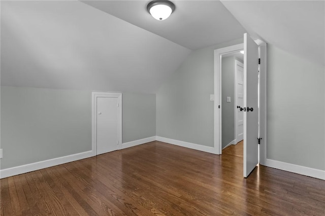 additional living space with vaulted ceiling and dark wood-type flooring