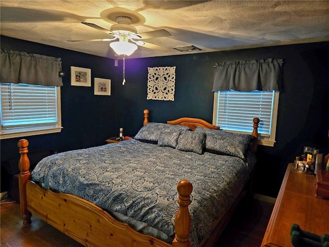 bedroom with ceiling fan and a textured ceiling