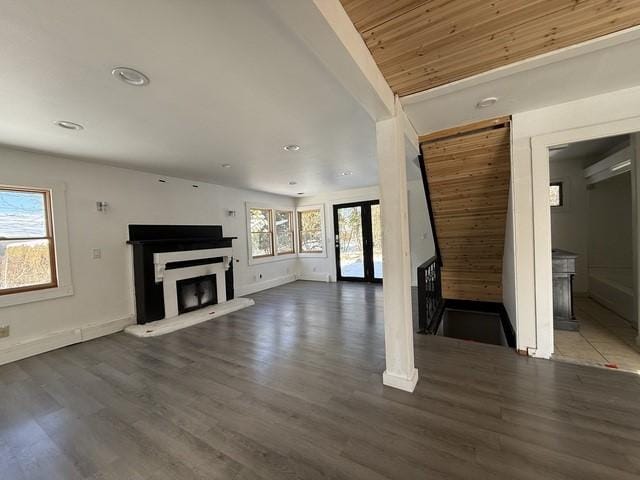 unfurnished living room with wood ceiling and dark hardwood / wood-style flooring