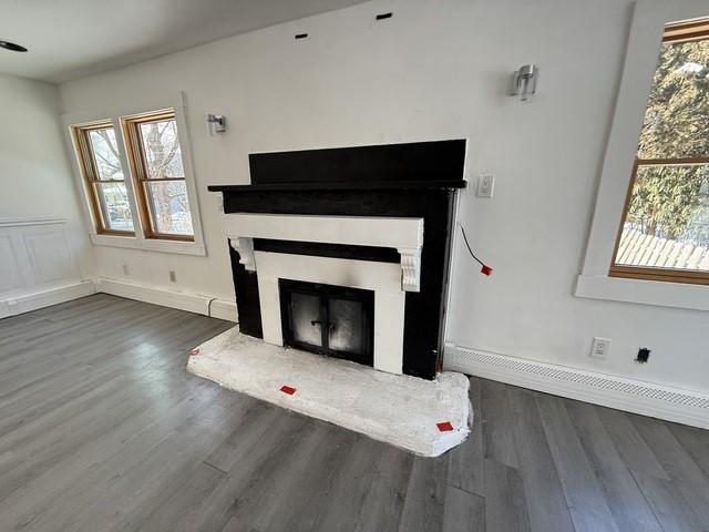 unfurnished living room with a healthy amount of sunlight and dark hardwood / wood-style floors