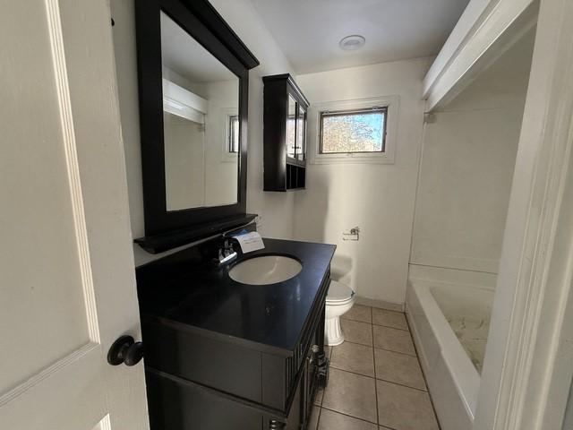 bathroom featuring vanity, a shower, tile patterned floors, and toilet