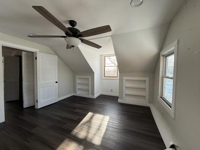 bonus room featuring lofted ceiling, dark hardwood / wood-style floors, and built in features