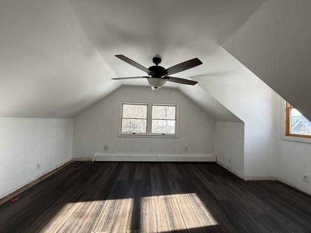 additional living space featuring lofted ceiling, a wealth of natural light, dark hardwood / wood-style floors, and ceiling fan