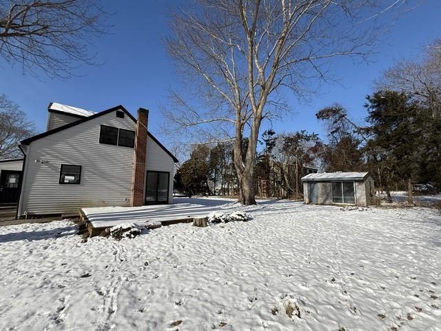 yard covered in snow with an outbuilding