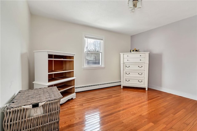 unfurnished office featuring wood-type flooring and a baseboard heating unit