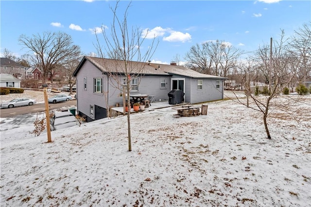 snow covered property featuring an outdoor fire pit